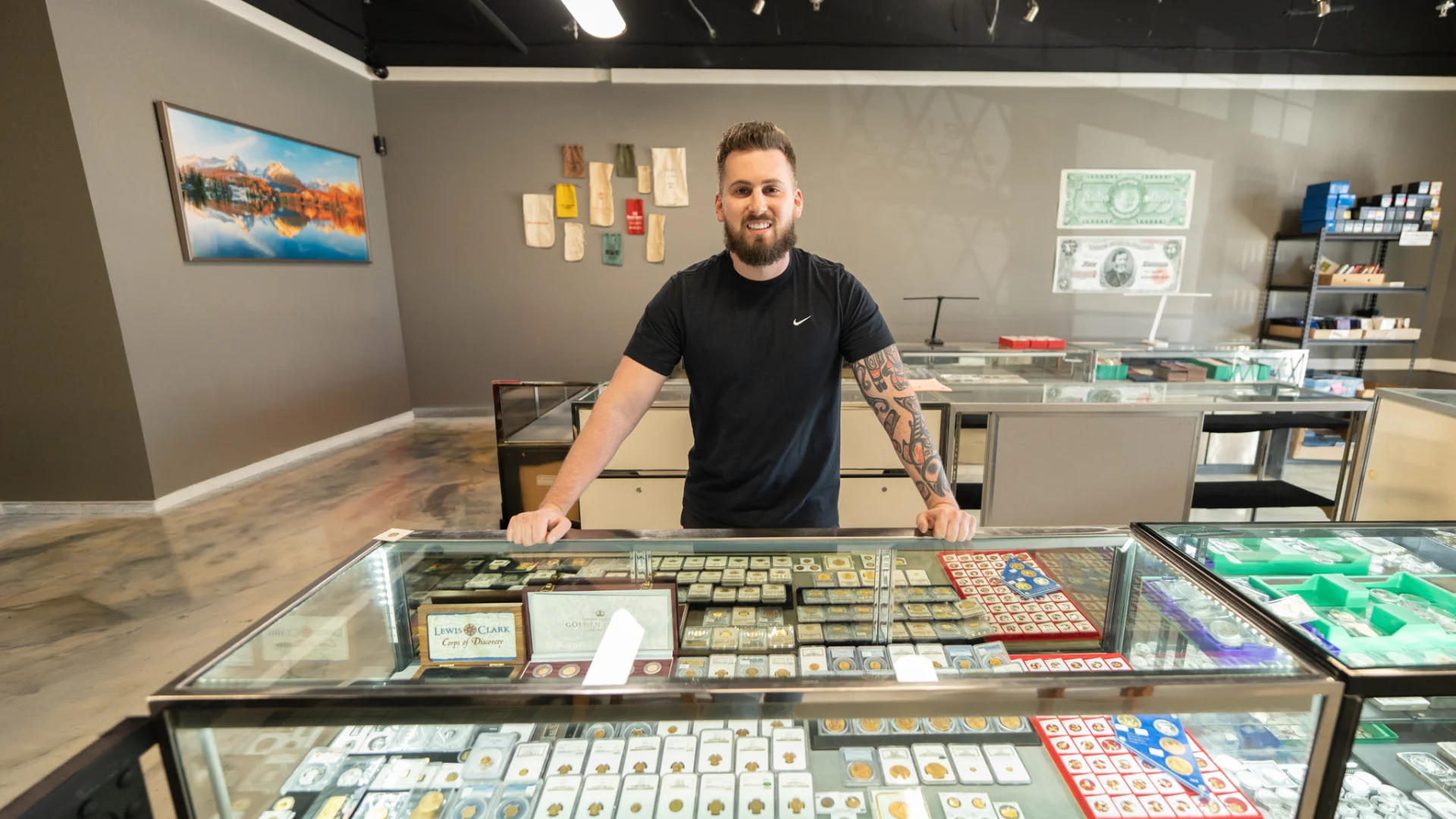 David Tine inside the Eagle Coin & Precious Metals showroom, standing behind display cases full of coins